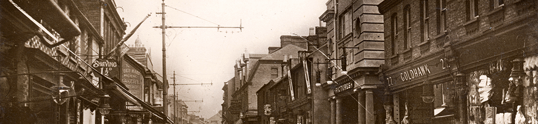High Town image from a postcard dating between 1912 and 1924. Sepia with no cars and the original building, viewed from the Midland Road upwards.